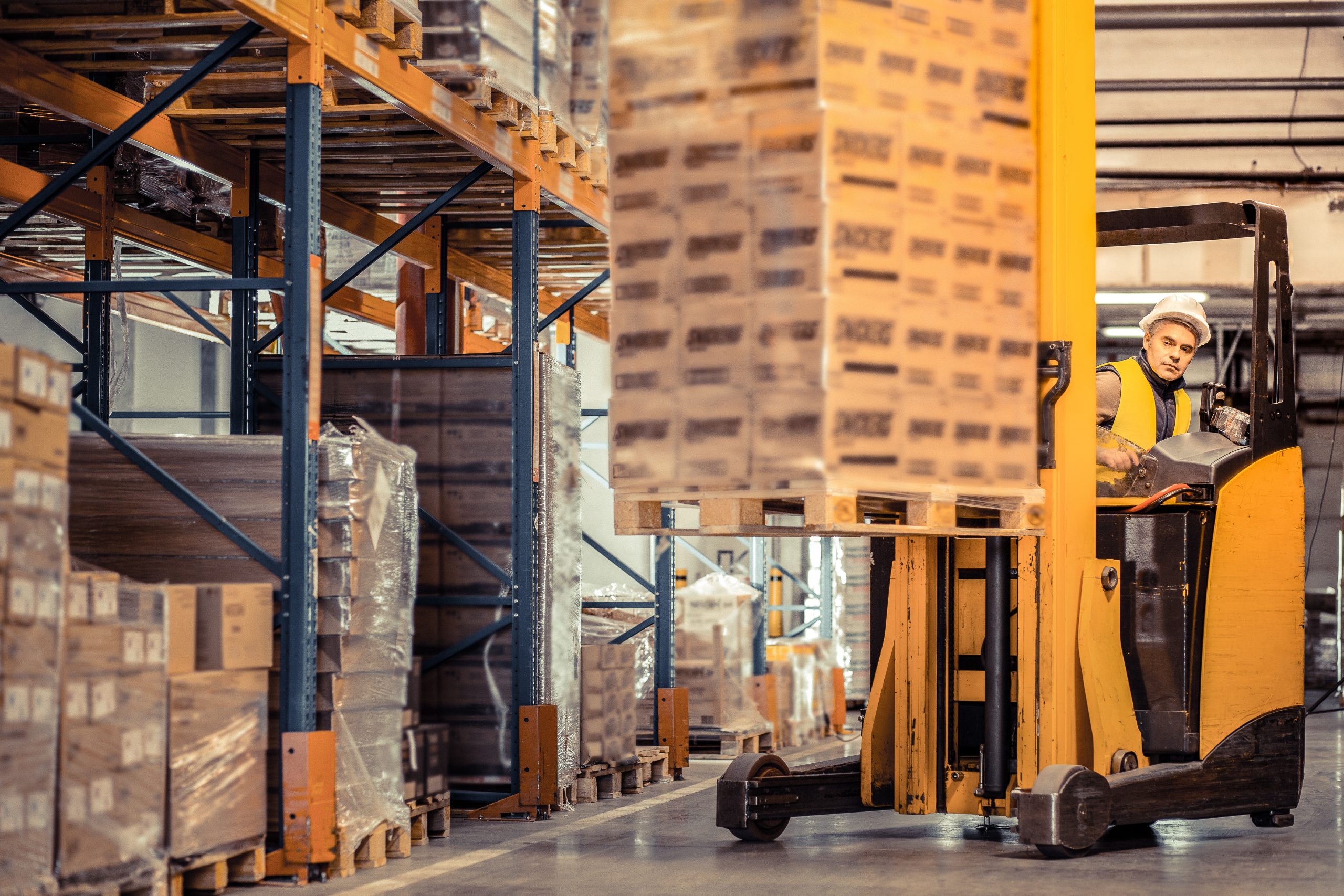 Attentive man putting pale of boxes on support